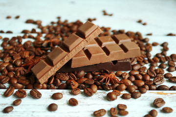 Chocolate with star anise and coffee beans on wooden background