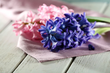 Beautiful hyacinth flowers on wooden table with napkin, closeup