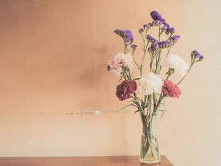 Beautiful summer flowers in vases on wooden background