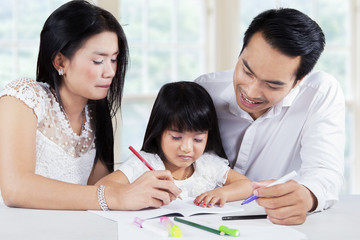 Child studying with parents in home