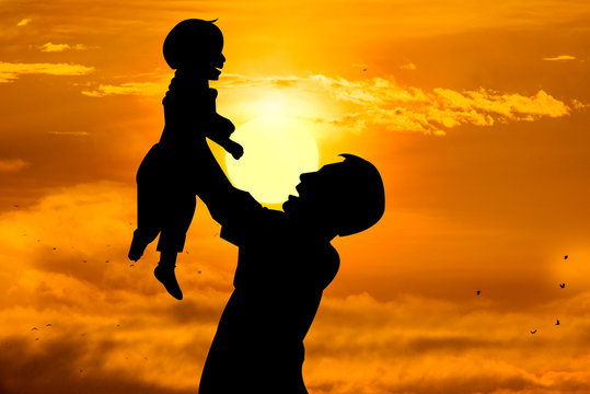 Father holding his child with rising sun, Father's day concept