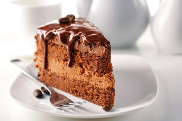 Delicious chocolate cake on plate on table on light background