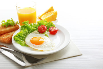 Bacon and eggs on color wooden table background