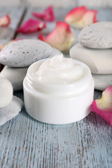 Fototapeta na wymiar Cosmetic cream with rose petals and spa stones