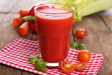 Glass of tomato juice with vegetables on wooden table close up