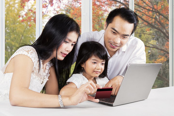 Family with laptop and credit card