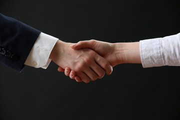 Business handshake on dark background