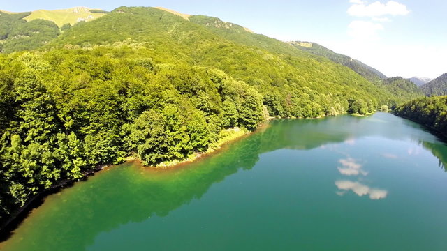 AERIAL: Flight over lake with forest around