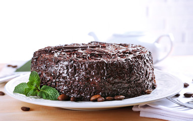 Tasty chocolate cake on table on brick wall background