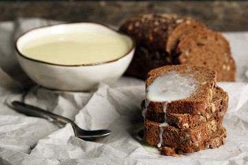Slices of bread with condensed milk on paper background