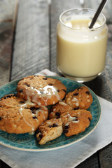 Cookies on plate with jar of condensed milk on wooden