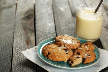 Cookies on plate with jar of condensed milk on wooden
