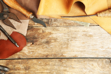 Leather and craft tools on wooden background