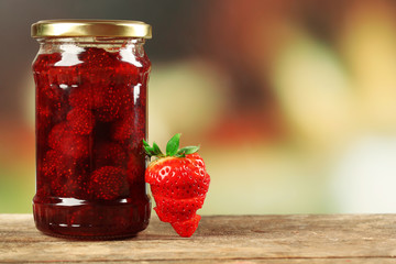 Jar of strawberry jam with sliced berry