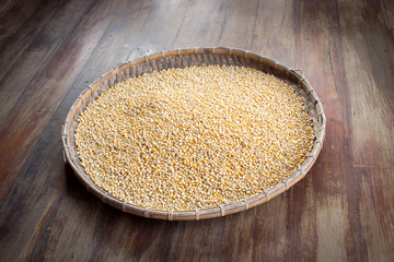 many corn seed in bamboo tray on wooden board