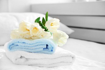 Fototapeta na wymiar White beautiful tulips on fresh towels in hotel, close up