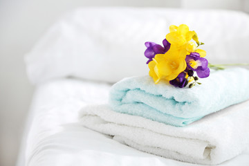 Obraz na płótnie Canvas Colorful beautiful freesias on fresh towels in hotel, close up