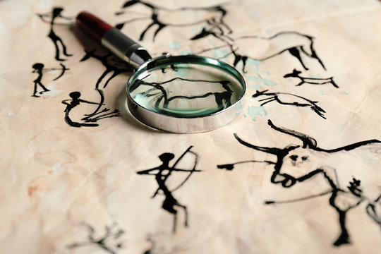 Rock paintings with magnifier on paper close up