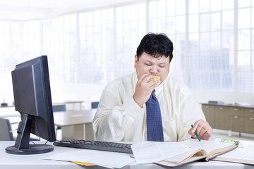 Worker reading book while eating burger