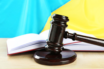 Wooden gavel and flag of Ukraine as background