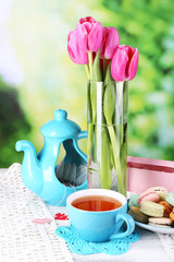 Composition of spring flowers, tea and cookies