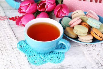 Composition of spring flowers, tea and cookies on table