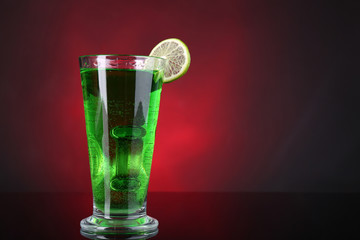 Flaming green cocktail on colorful background
