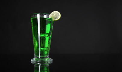 Flaming green cocktail on dark background