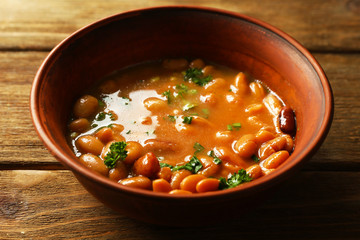 Bean soup in bowl on wooden table background