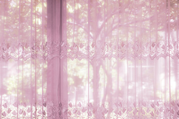 A bedroom windows dressed with striped curtain that lace drapery