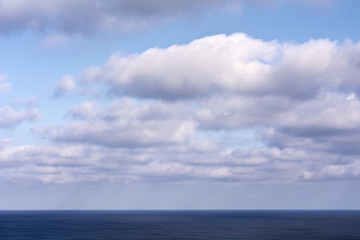 Obraz premium Cloudy blue sky over the blue sea