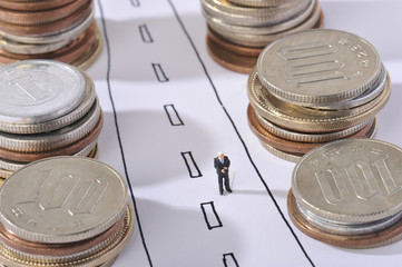 お金の山とゴールを見つめる男性