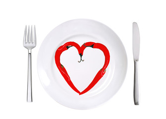 red hot chilly peppers, white plate, fork and knife isolated on