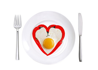 red hot chilly peppers and fried egg on white plate isolated on
