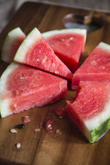 Sliced juicy watermelon on wooden chopping board