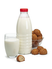 Plastic bottle, glass with milk and a vase with doughnuts