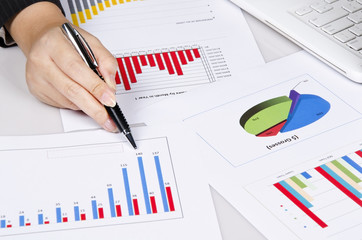 a hand pointing to business chart on the desk