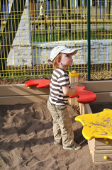 Little boy playing in sandpit in the park