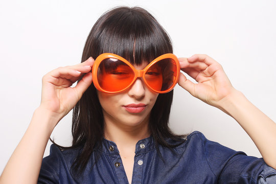 young happy woman with big orange sunglasses