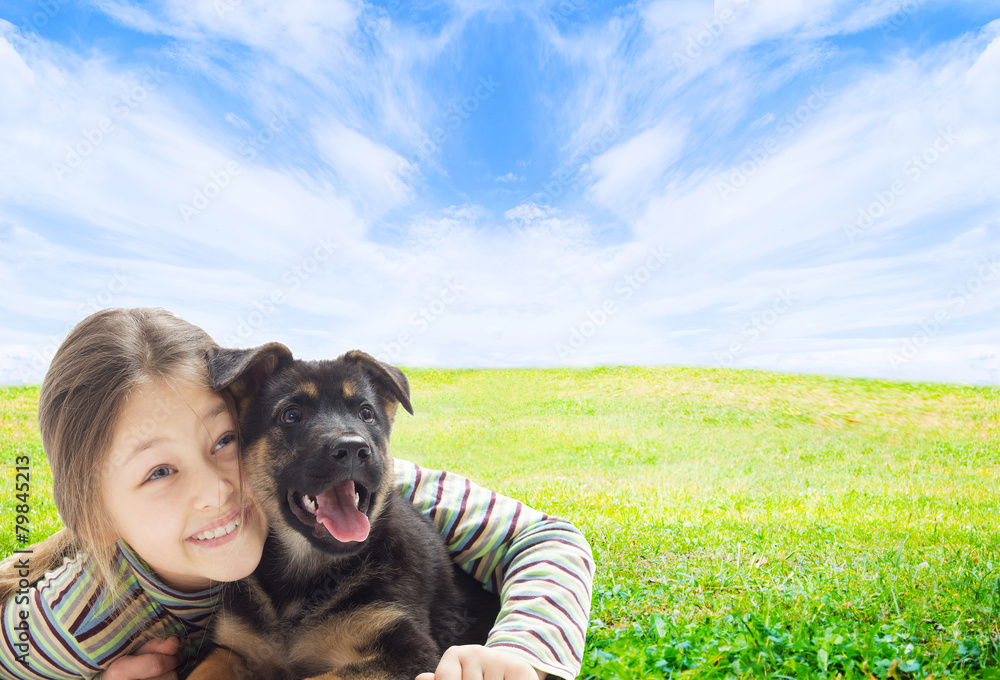 Wall mural positive kid with a puppy on a green lawn