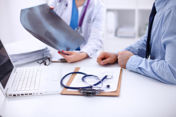 Doctor woman and patient sitting on the desk