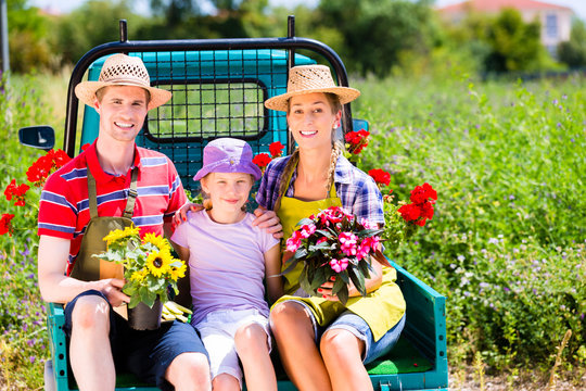 Familie auf Transporter mit Blumen im Garten