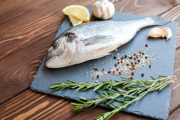 Raw dorado on the slate tray with herbs