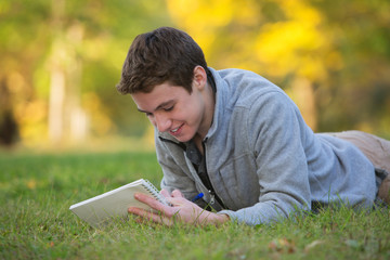 Happy Teen Writing on Grass