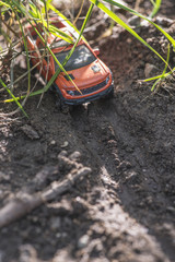 Small red off road car toy in the nature