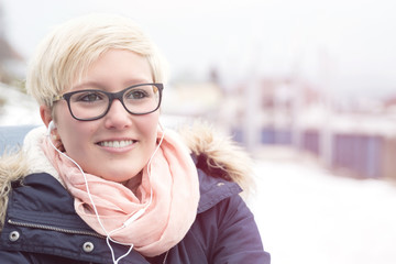 Young woman listening music outside in the cold