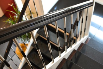Treppengeländer mit Edelestahlelementen an einer gefliesten Treppe