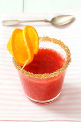 Strawberry smoothie topped with brown sugar, orange slice