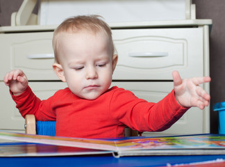 Small toddler or a baby child playing with puzzle shapes on a lo