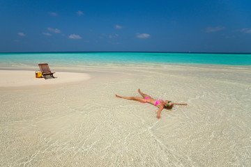 Fototapeta na wymiar Cute woman relaxing on the tropical beach